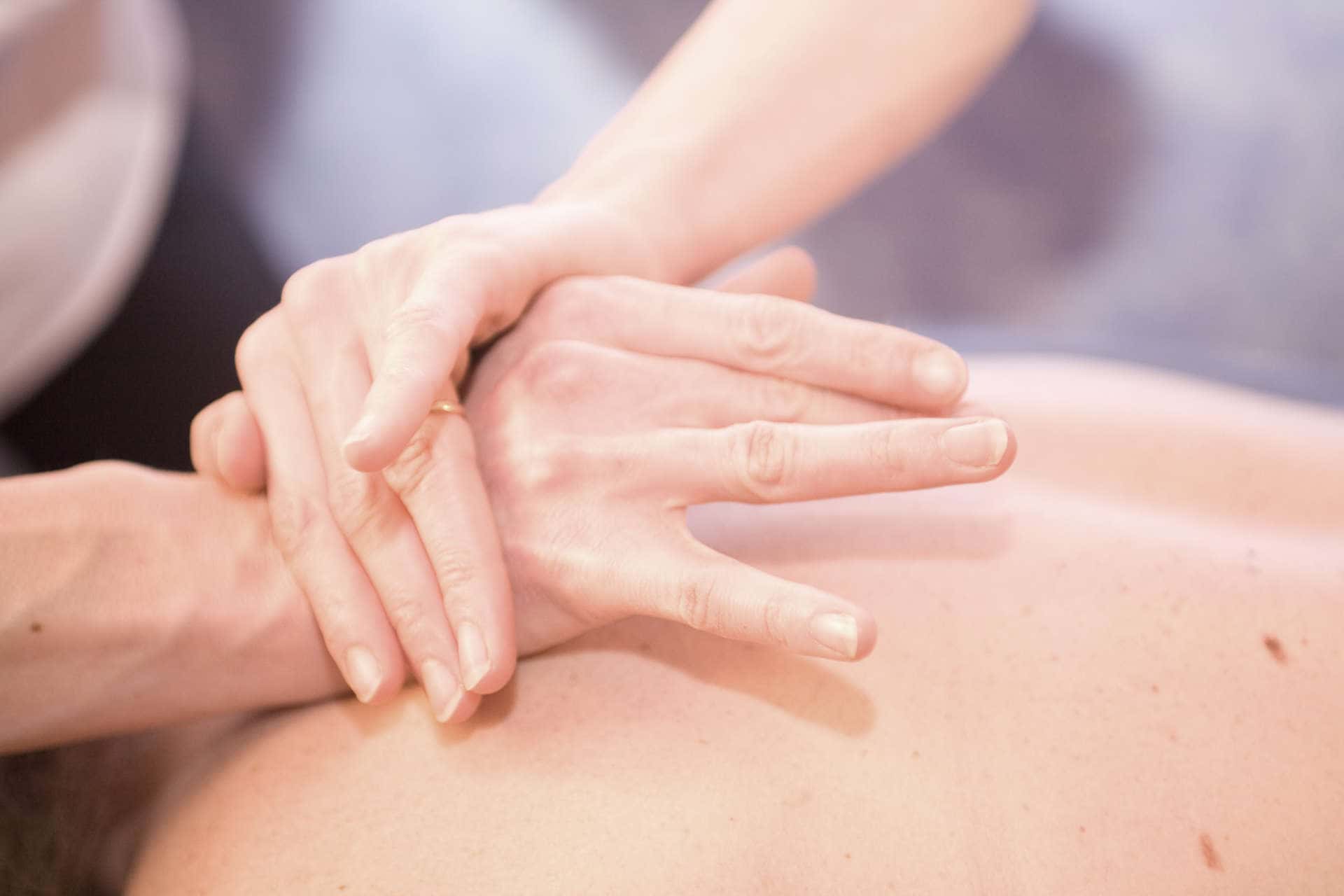hands on the upper back of massage patient